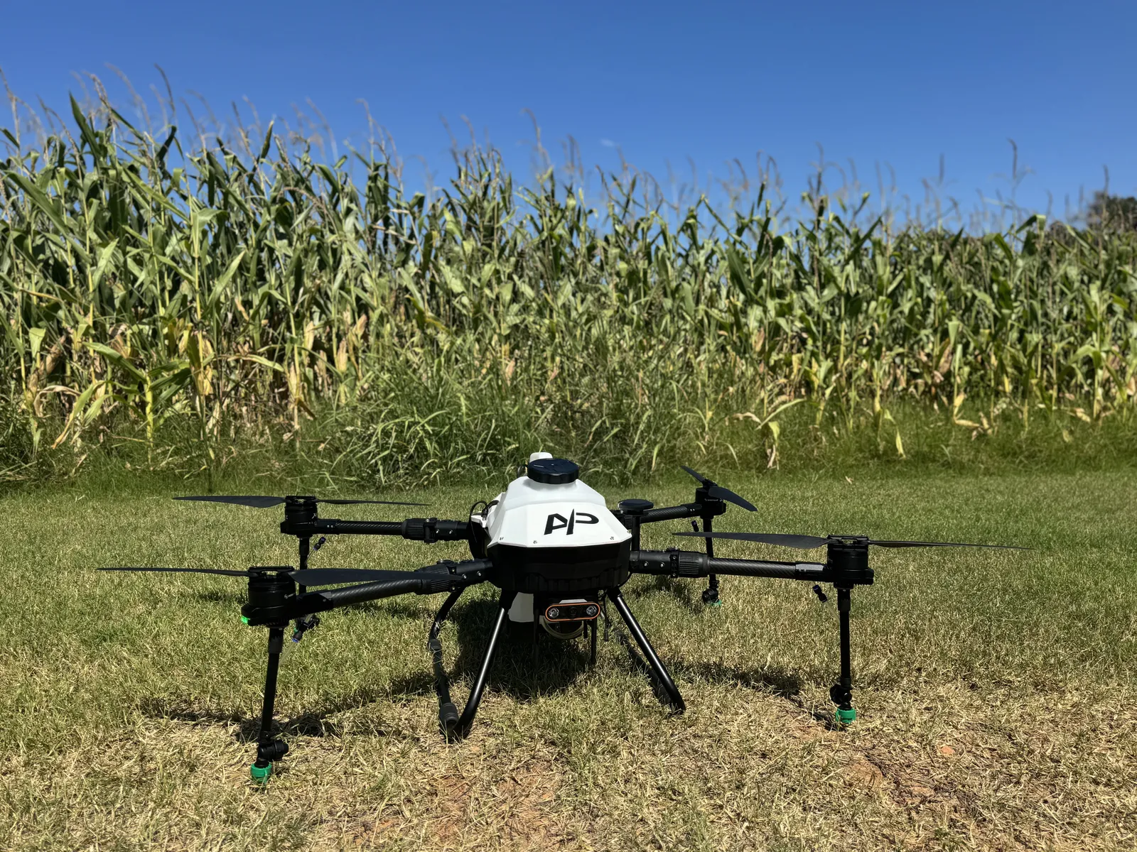 American Prime agricultural spray drone staged at the edge of a corn field