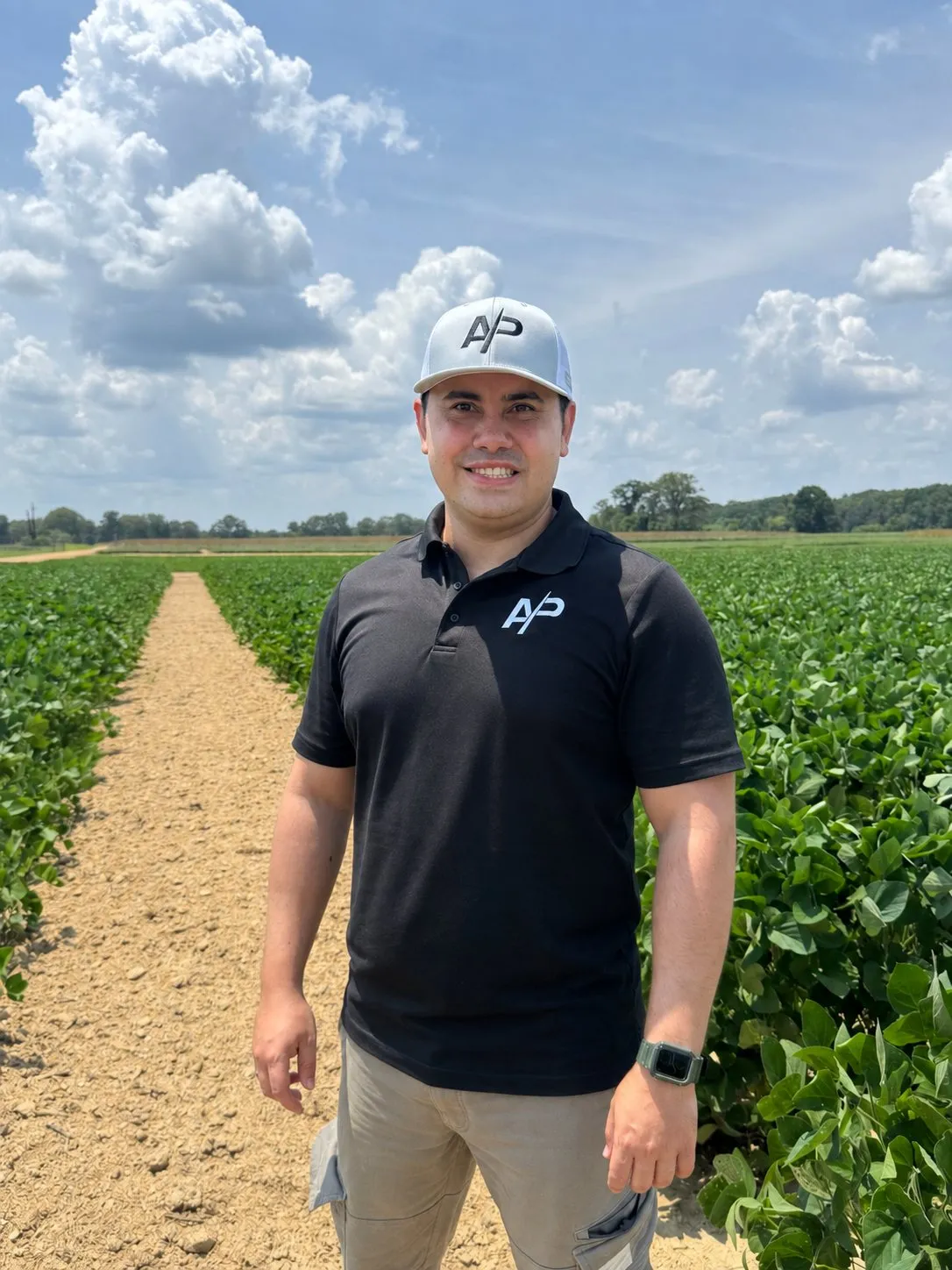 Jorge Celis standing between soybean rows during a field visit