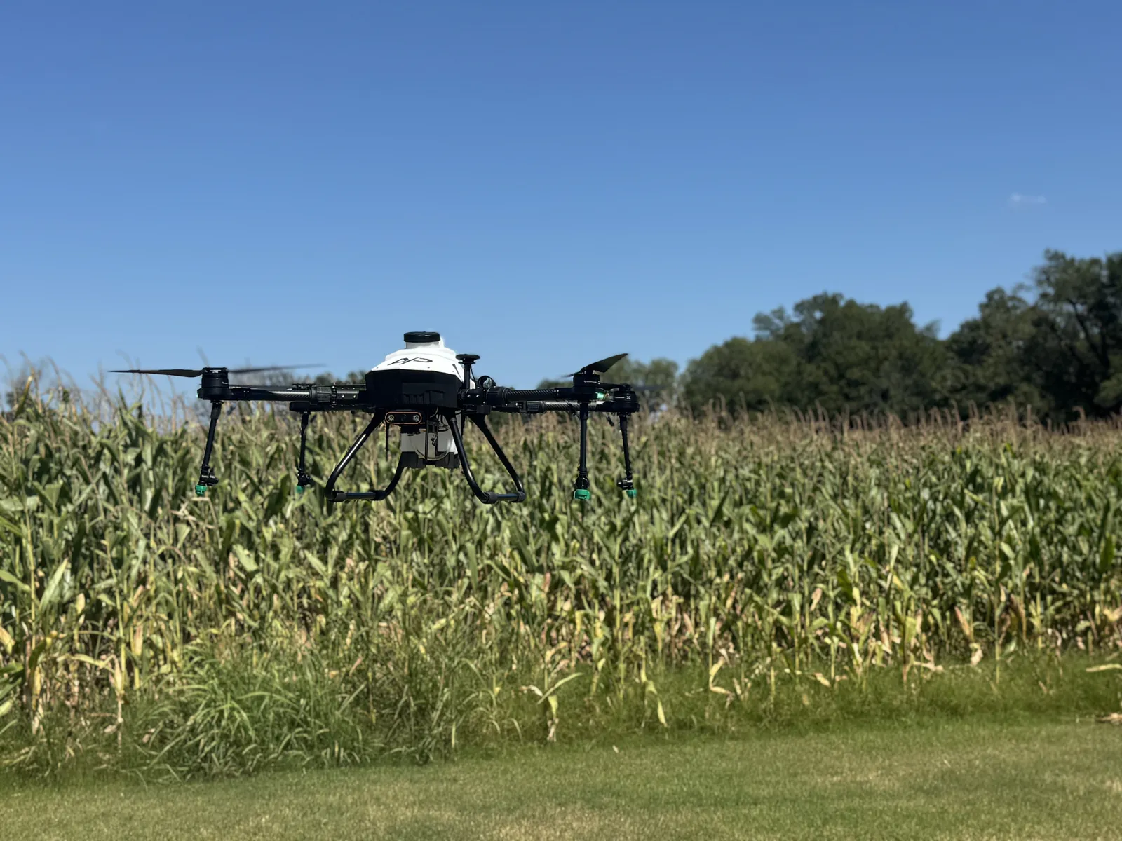 American Prime spray drone in flight low over a corn field during field validation